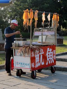 a man standing next to a food cart