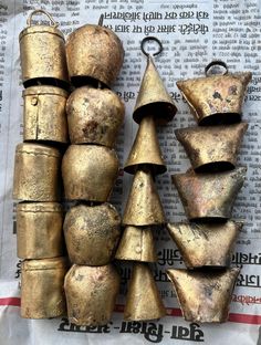 several pieces of gold colored metal sitting next to each other on top of a newspaper