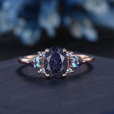 an oval shaped blue diamond surrounded by three smaller diamonds on top of a black surface