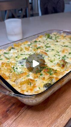 a casserole dish with cheese and vegetables in it on a wooden cutting board