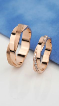 two rose gold wedding rings with diamonds on the inside, sitting next to each other