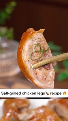 the chicken legs are being held up by chopsticks