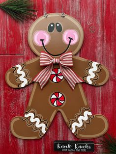 a christmas ornament with a ginger bear on it's face and candy canes in its mouth