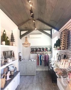 the inside of a store with lots of items on shelves and lights hanging from the ceiling