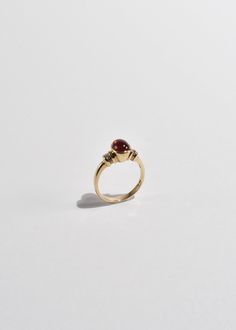 Beautiful vintage gold ring with a polished ruby cabochon and diamond detail. Stamped 10k. Material: 10k gold, ruby, diamond. We recommend storing in a dry place and periodic polishing with a cloth.