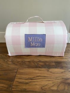 a pink and white checkered duffel bag with the name miller mode on it