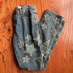 an old pair of jeans with stars on them sitting on the floor next to each other