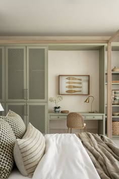 a bedroom with green cabinets and white bedding