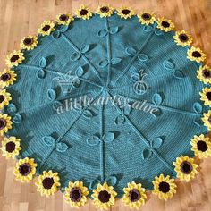 a crocheted sunflower doily is shown on a wooden floor with the words,'little sunshine'written across it