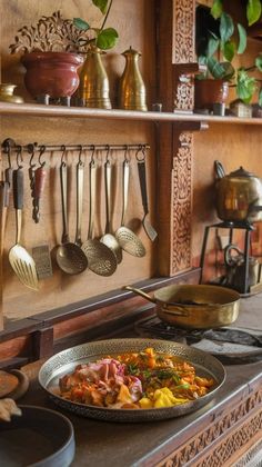 an old fashioned kitchen with pots, pans and utensils hanging on the wall