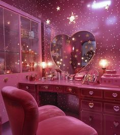 a pink vanity with stars on the ceiling and a heart shaped mirror above it in a bedroom