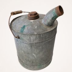 an old metal bucket with a pipe sticking out of it