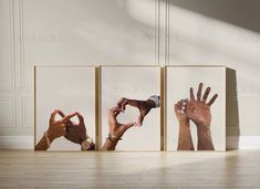 three frames with different hands on them in front of a white wall and wooden floor