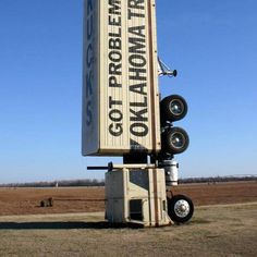 a large sign sitting in the middle of a field