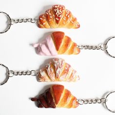 three croissants with different toppings on them are being held by chains