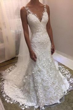 a woman standing in front of a mirror wearing a wedding dress