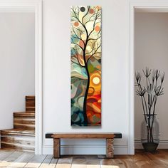 a painting hanging on the wall next to a wooden bench in a room with white walls