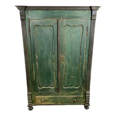 an old green painted armoire with two doors