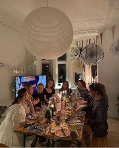 a group of women sitting around a table with food and drinks in front of them