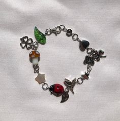 Forest Charm Bracelet 7 inches - Silver Chain Mushroom Leaf Ladybug Stars Humming bird heart flower Cottagecore Fairycore Garden Forest Fair The bracelet shown is 7 inches long. The beads on the bracelet may vary slightly if you order a different length. For example if you order a 6.5 inch bracelet, the bracelet may not have the flower bead at the end. Multicolor Fairycore Jewelry For Gifts, Fairycore Multicolor Jewelry For Gifts, Handmade Multicolor Fairycore Jewelry, Fairycore Garden, Flower Cottagecore, Cottagecore Accessories, Garden Forest, Pretty Jewelry Necklaces, Edgy Jewelry