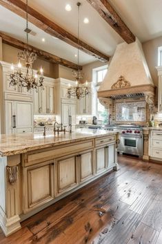 a large kitchen with wooden floors and an island in front of the stove top oven