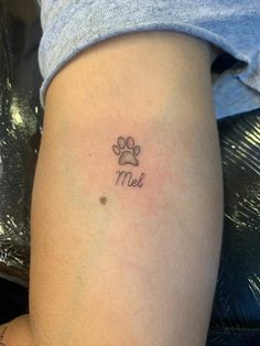 a small dog paw tattoo on the left thigh and right leg, it says me