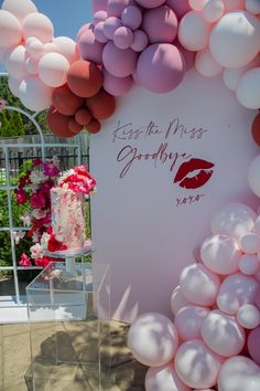 a display with balloons and a sign that says kiss the miss goodbye