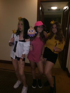 three girls dressed up in costumes posing for the camera