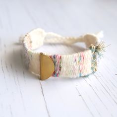 a close up of a bracelet on a white table with a wooden tag attached to it