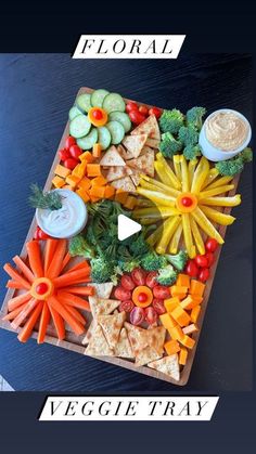 a platter filled with veggies and dips on top of a table