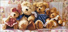 a group of teddy bears sitting next to each other on a floral covered bed sheet