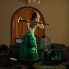 a woman in a green dress holding an ax