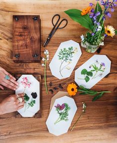 people are working on their flower arrangements with scissors and cutting board in front of them