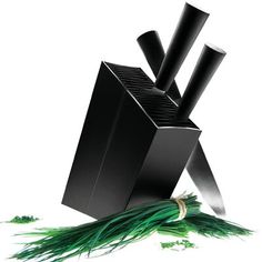 an illustration of a black box with knives sticking out of it's sides and some green grass in the foreground