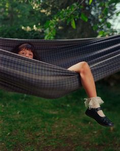 a woman laying in a hammock with her feet up