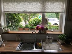 a kitchen sink under a window next to a wooden counter