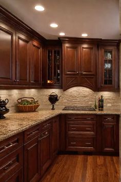 a kitchen with wooden cabinets and marble counter tops