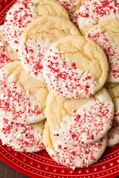 a plate full of cookies with white and red sprinkles