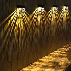 three lights shine brightly on the wall in front of a bench with benches underneath it