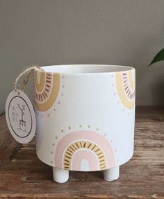 a white pot with a pink and yellow design on it