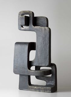 an abstract sculpture made out of metal on a white surface