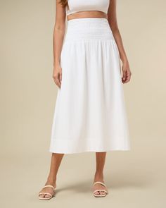 This pull-on skirt has a wide smocked waistband that opens to a full, midi silhouette in cotton poplin. Midi length Wide smocked waistband Pull on Full a-line skirt 97% Cotton 3% Spandex Machine wash with like colors. Do not bleach. Hang to dry. Iron warm. The Smocked Midi Skirt is styled with the Smocked Crop Top. Spring Midi Skirt With Gathered Waist, Casual Bottoms With Gathered Waist, Midi Length, Casual Midi-length Bottoms With Gathered Waist, Skirted Bottoms With Elastic Waistband For Daywear, Casual Midi Bottoms With Gathered Waist, Casual Midi Length Skirt With Gathered Waist, Casual Midi Skirt With Gathered Waist, Spring Maxi Skirt With Gathered Waist, Spring Maxi Skirt With Elastic Waistband For Daywear