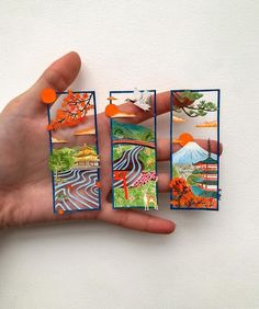 a hand holding four cards with different pictures on them