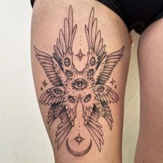 a woman's thigh with an owl and moon tattoo on her leg, showing the lower part of her thighs