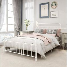 a white bed sitting in a bedroom next to a window