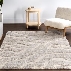 a living room area with a white rug and chair next to a small end table