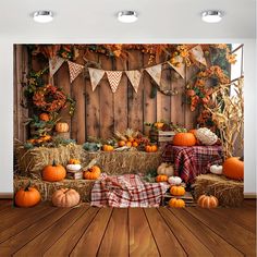 a room with hay bales and pumpkins on the floor in front of a wooden fence