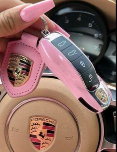 a pink car steering wheel with the emblem on it's center console and keychain