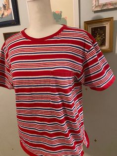 Vintage 100% cotton red, white, and navy blue striped short sleeve T-shirt with a pocket on the left chest.  Label: Lizsport  Size: small 100% cotton  Measurements taken flat, please double where needed Shoulder to shoulder: 17 inches  Underarm to underarm: 19 inches  Sleeve length: 7.25 inches  Shoulder to hem: 21.5 inches Casual Short Sleeve T-shirt With Vertical Stripes, Red Short Sleeve Tops With Vertical Stripes, Casual Striped T-shirt With Three Stripes, Casual Red T-shirt With Contrast Stripes, Red Cotton Top With Vertical Stripes, Red Cotton Tops With Vertical Stripes, Casual Red T-shirt With American Flag Print, Casual T-shirt With Vertical Stripes And Short Sleeves, Red Casual T-shirt With American Flag Print