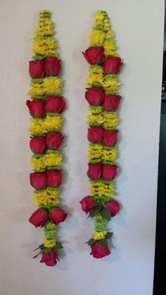 two red and yellow flowers are hanging on the wall